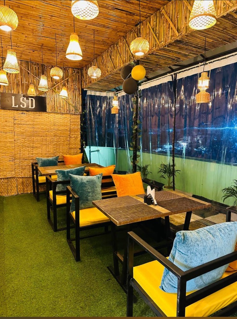 LSD interior with bamboo walls, yellow cushions and city view at night