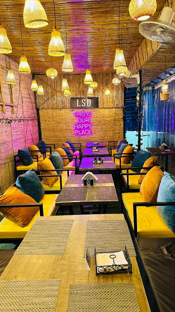 LSD neon sign This Is Our Happy Place with purple lights and yellow sofas